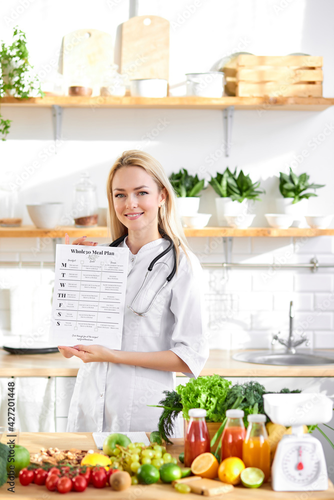 Doctor holding healthy balnced diet list for clients in hands Doctor holding healthy balnced diet list for clients in hands
