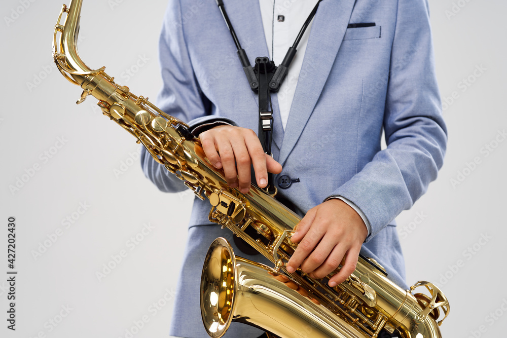 Naklejka premium boy with saxophone in hand musical education instrument model
