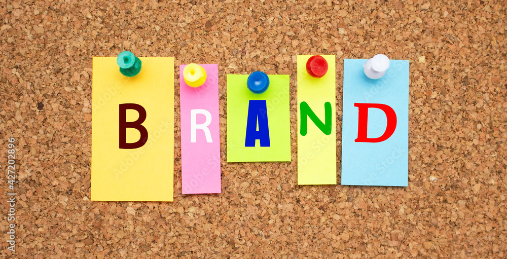 Color notes with letters pinned on a board. Word BRAND. Color notes with letters pinned on a board. Word BRAND.