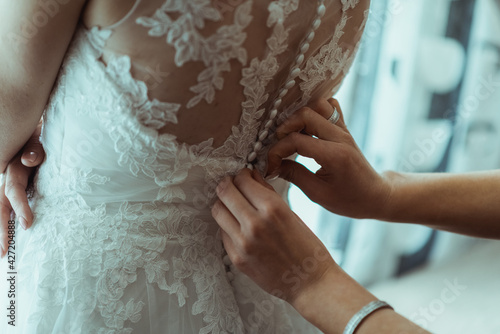 the bride wears a wedding dress, the godmother helps her