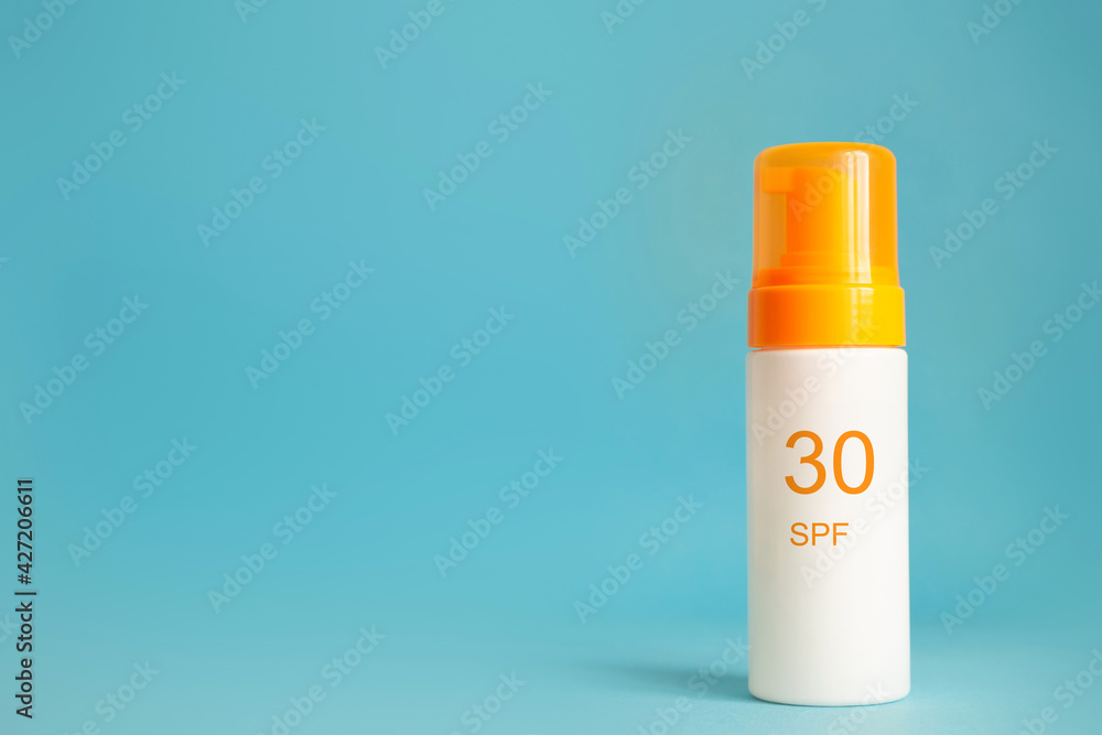 Sunscreen bottle with spf 30 cream or lotion on the aqua blue background with copy space. Sun protection, sunblock, uv cosmetic Sunscreen bottle with spf 30 cream or lotion on the aqua blue background with copy space. Sun protection, sunblock, uv cosmetic
