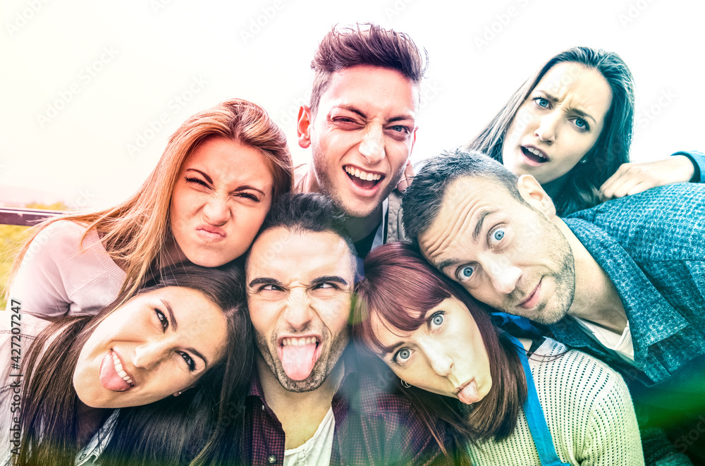 Multicultural millenial friends taking selfie with funny faces - Happy youth friendship concept with millennial young trendy people having fun together with tongue out - Bright multicolor filter Multicultural millenial friends taking selfie with funny faces - Happy youth friendship concept with millennial young trendy people having fun together with tongue out - Bright multicolor filter