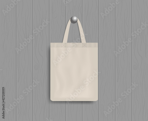 White tote on wood wall. Mockup of eco canvas bag with handle. Cotton fabric tote. Reusable cloth of ecobag for shopping, grocery, market, beach. Realistic fashion handbag. Template of design. Vector