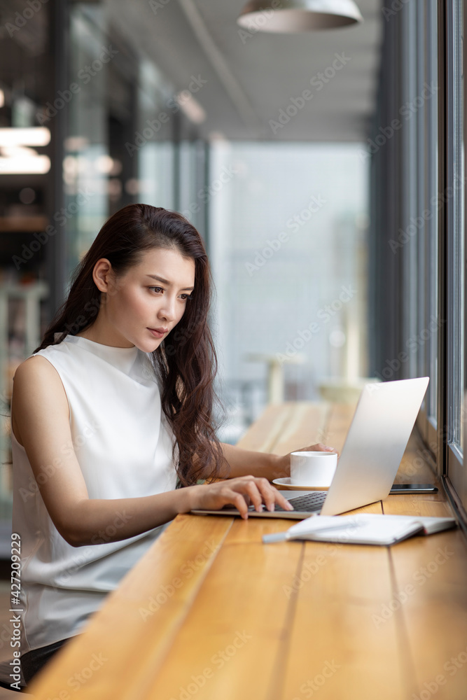 Businesswoman working with laptop in caf�� Businesswoman working with laptop in caf��