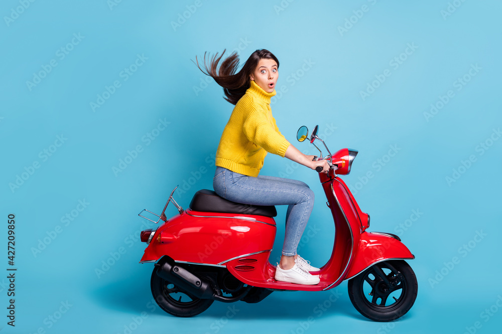 Profile side view portrait of nice attractive amazed girl riding moped fast  speed pout lips isolated over bright blue color background Stock Photo |  Adobe Stock