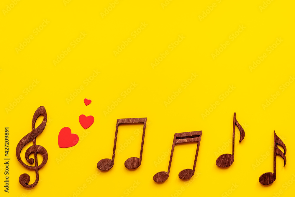 Love songs - musical wooden notes with heart, top view Love songs - musical wooden notes with heart, top view