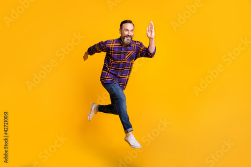Full length body size photo of man jumping high running fast on sale isolated on vibrant yellow color background