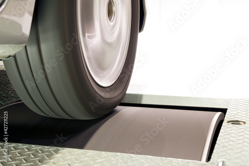 Fotografía Close up of vehicle tire and rim rotation with blurry motion on roller Chassis d