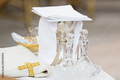 Liturgical objects, sacred vessels: glass altar cruet and liturgical bowl near the altar during the Holy Mass in the Catholic Church photo