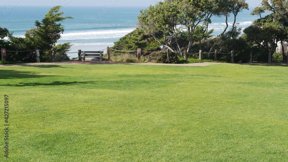 Seagrove recreation beach park in Del Mar, California USA. Seaside garden with lawn in waterfront resort. Green grass and ocean coast view from above. Picturesque coastline vista point on steep hill.