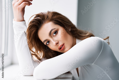 Close up portrait of sensual pretty young woman in white clothes