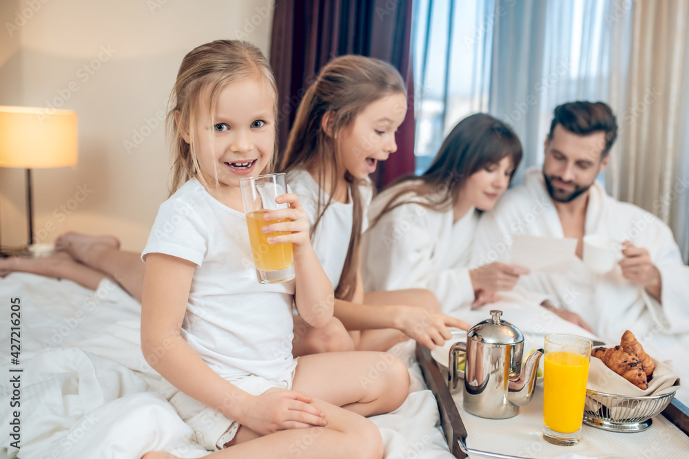 Parents and kids having breakfast and looking contented Parents and kids having breakfast and looking contented