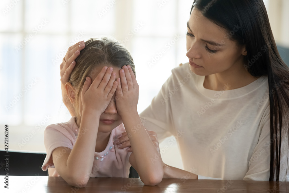 Caring young Caucasian mother comfort caress upset sad little daughter having bullying problems at school. Loving mom support unhappy small girl child crying feeling bad. Family trouble concept. Caring young Caucasian mother comfort caress upset sad little daughter having bullying problems at school. Loving mom support unhappy small girl child crying feeling bad. Family trouble concept.