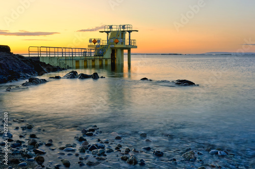 Obraz na płótnie Beautiful morning orange sunrise scenery at Blacrock diving tower on Salthill beach in Galway, Ireland w salonie
