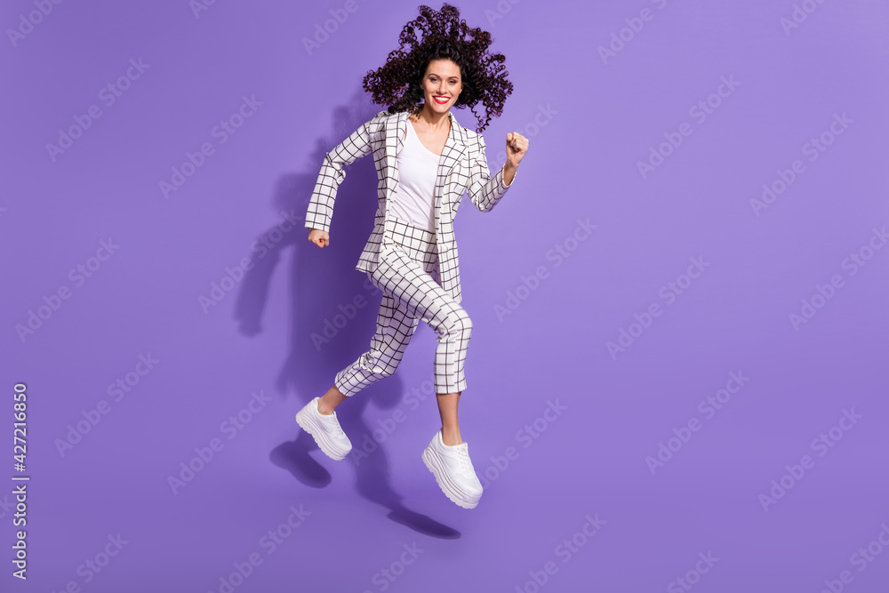Full length photo portrait of charming girl running jumping up isolated on vivid purple colored background Full length photo portrait of charming girl running jumping up isolated on vivid purple colored background