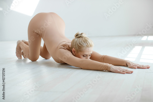 Woman doing yoga pose, exercising in the studio over the panoramic window. High quality photo.