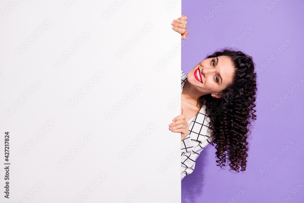 Photo portrait of woman in blazer hiding near white wall with empty space smiling isolated on vivid violet color background Photo portrait of woman in blazer hiding near white wall with empty space smiling isolated on vivid violet color background