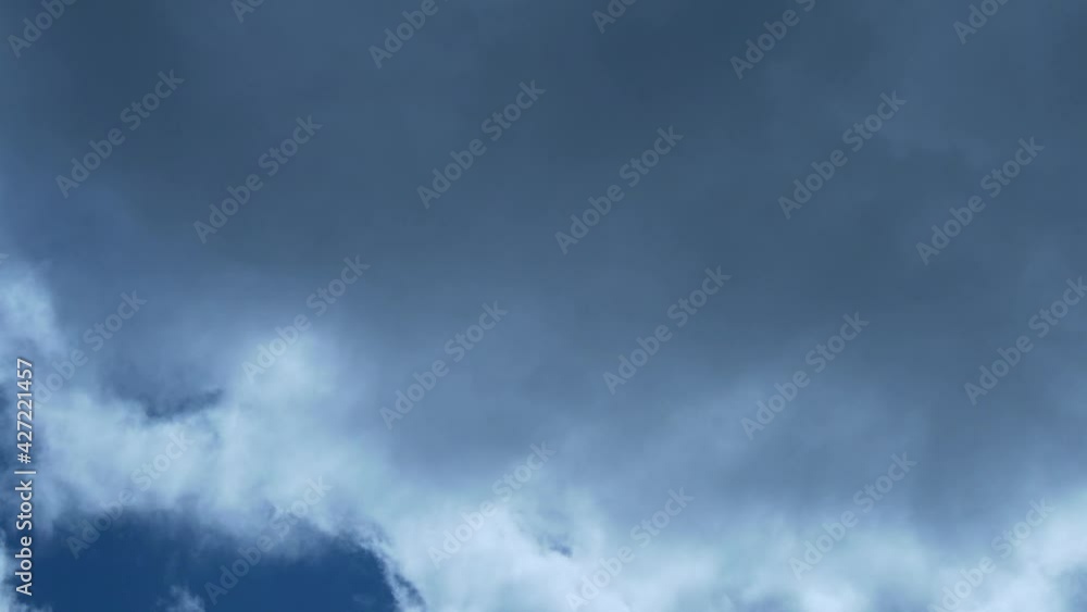 Very Fast Beautiful Time Lapse of White Fluffy Cumulus Clouds of the Shining Sun with Highlights Rays through the Clouds and Blue Sky on A Cloudy Day. The Sun Shines Through The Fast-Moving Clouds. Very Fast Beautiful Time Lapse of White Fluffy Cumulus Clouds of the Shining Sun with Highlights Rays through the Clouds and Blue Sky on A Cloudy Day. The Sun Shines Through The Fast-Moving Clouds.