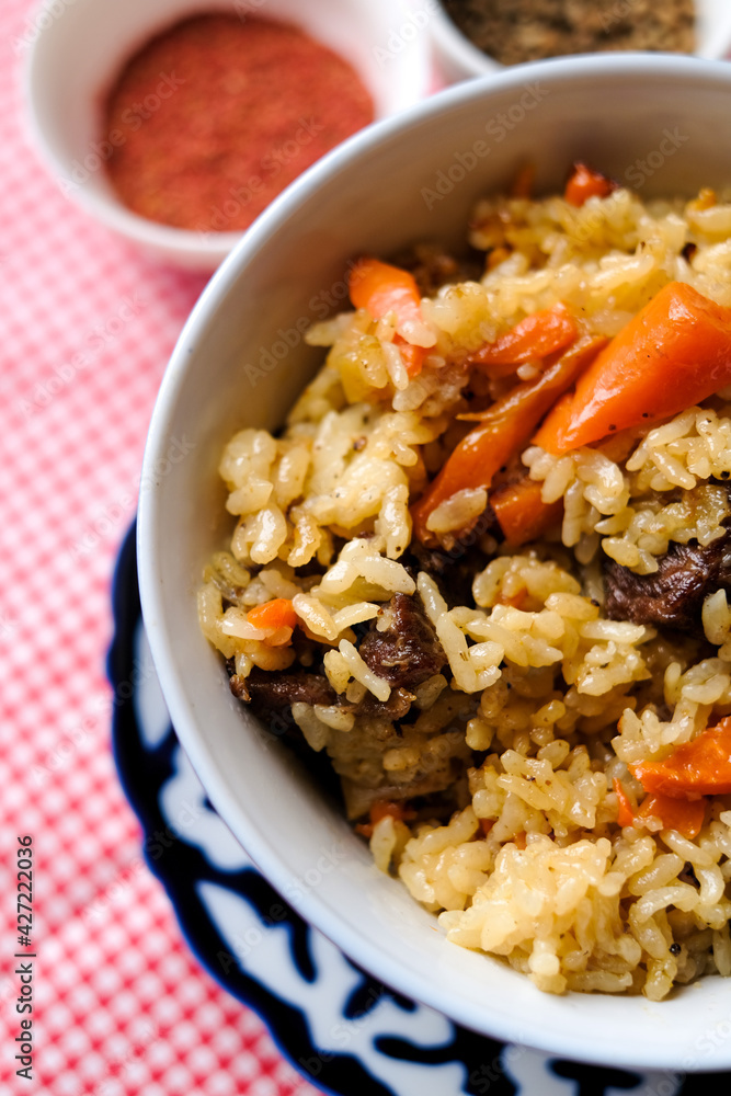 Bowl of asian food pilaf with rise, carrot and spices at table background Bowl of asian food pilaf with rise, carrot and spices at table background