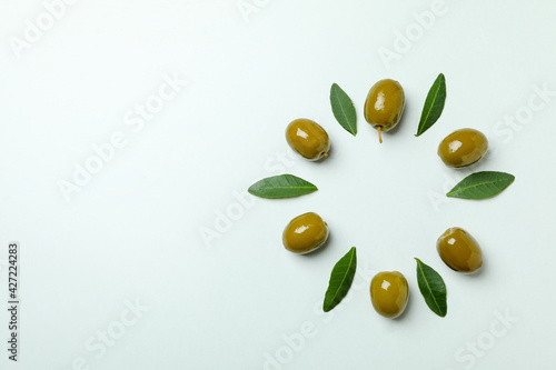 Green olives and leaves on white background