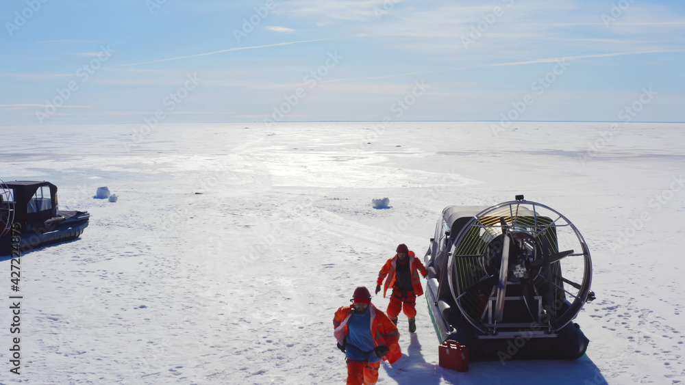 Rescuers jumping off air boat and running to save drowning in arctic Rescuers jumping off air boat and running to save drowning in arctic