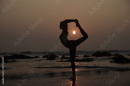 silhouette of a person in yoga asana on a sunset