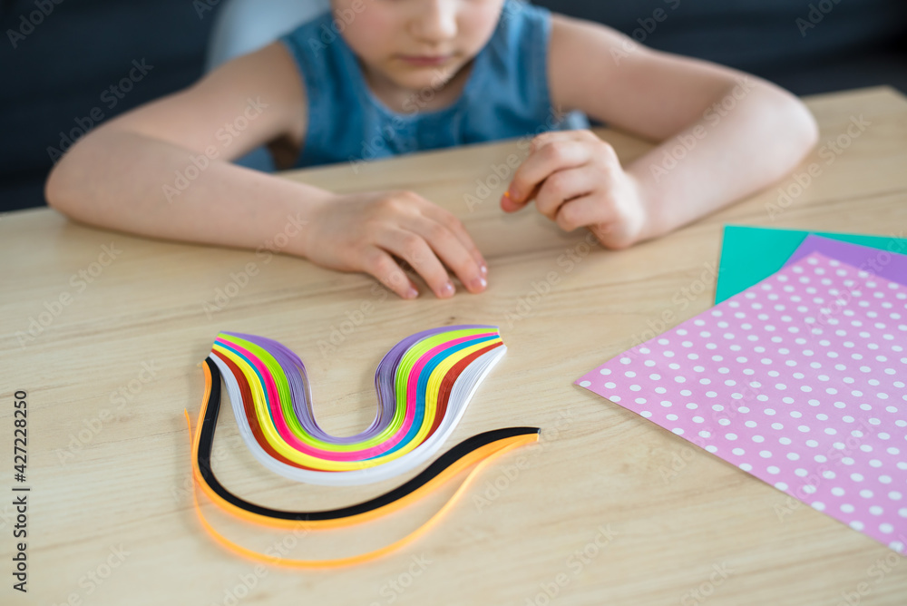 A preschool girl makes сolorful quilling, creativity for children, activities for a child in quarantine. Isolation, coronavirus 2021. A preschool girl makes сolorful quilling, creativity for children, activities for a child in quarantine. Isolation, coronavirus 2021.