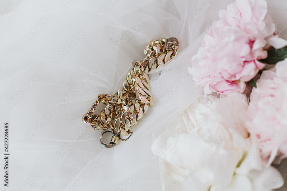 Stylish accessories on soft tulle fabric with peony bouquet. Bridal morning. Feminine essentials Stylish accessories on soft tulle fabric with peony bouquet. Bridal morning. Feminine essentials