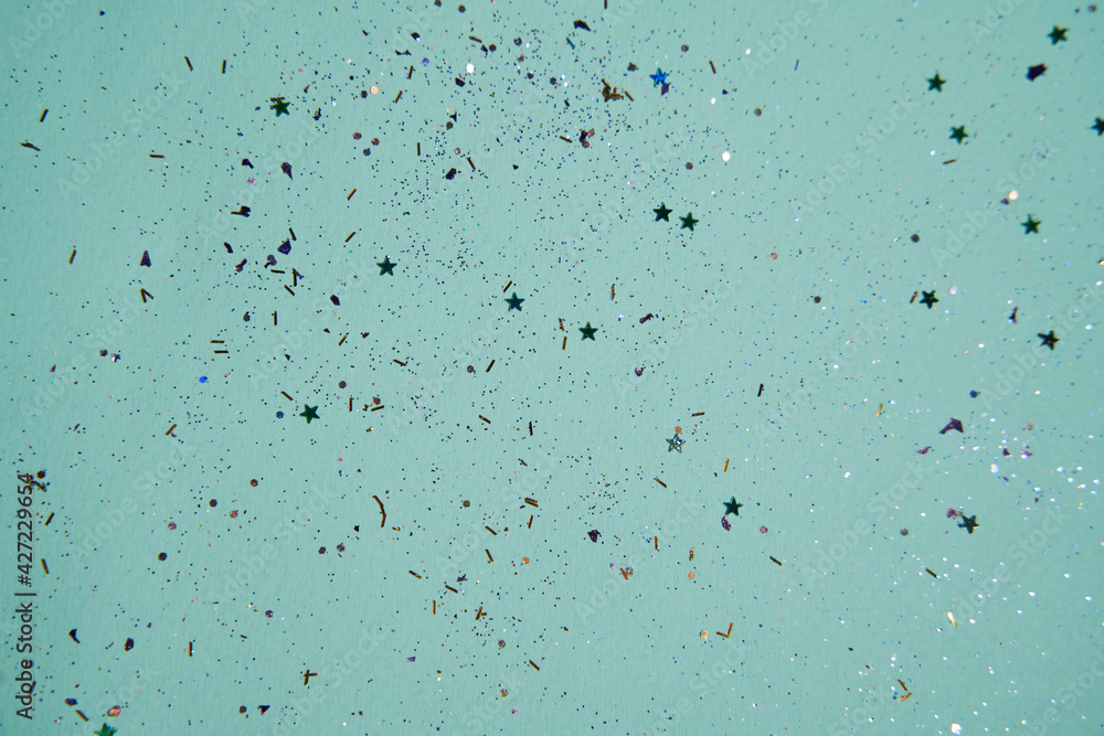 Shiny sequins scattered on a green background Shiny sequins scattered on a green background