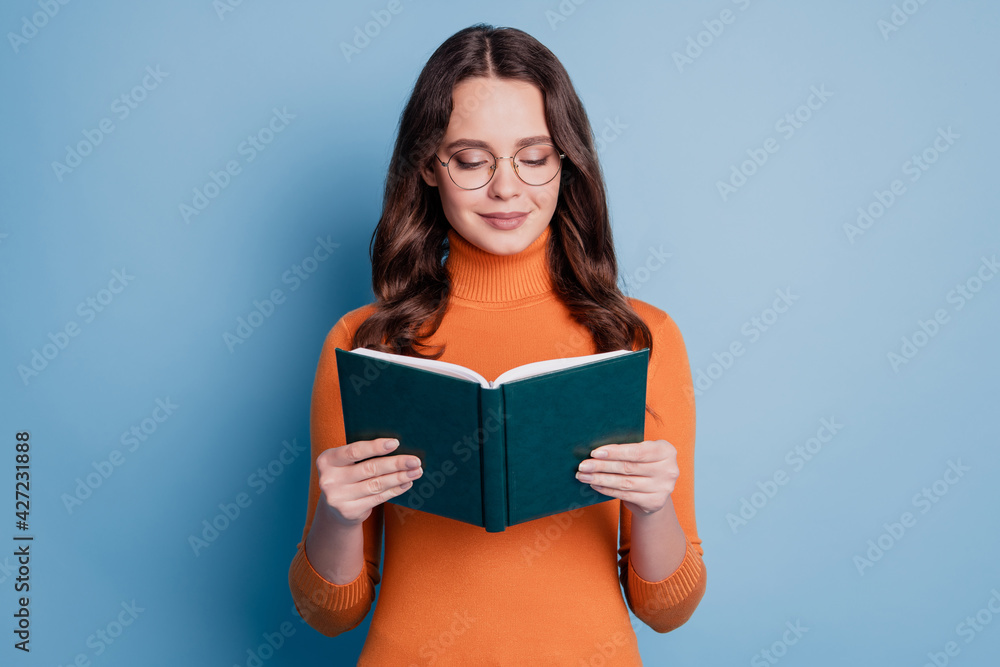 © Tetiana - Photo of dreamy peaceful woman read book focused face posing on blue background © Tetiana - Photo of dreamy peaceful woman read book focused face posing on blue background