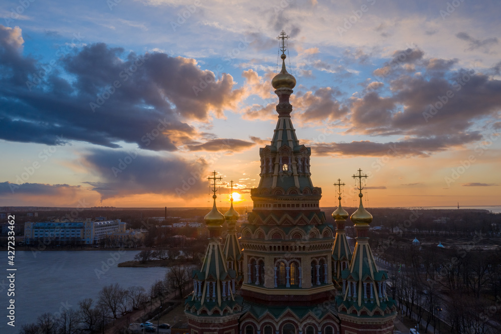 Aerial view of the Cathedral of Saints Peter and Paul, golden domes in the beautiful setting sun. Orthodox church in Peterhof. Facade of the church close-up.