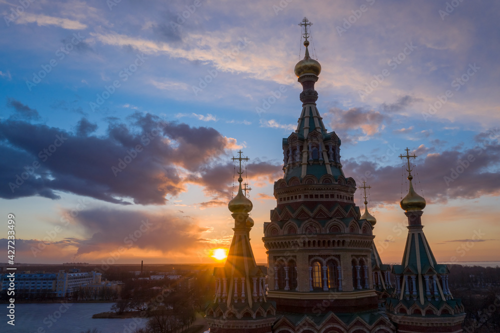 Aerial view of the Cathedral of Saints Peter and Paul, golden domes in the beautiful setting sun. Orthodox church in Peterhof. Facade of the church close-up.