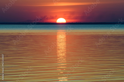 Fototapeta Naklejka Na Ścianę i Meble -  Bright beautiful sunset at the calm sea. Solar disk over water.