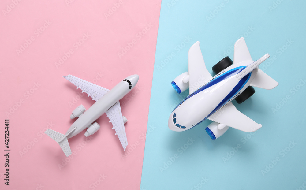 Model of a toy passenger planes on a blue-pink pastel background. Travel concept. Top view