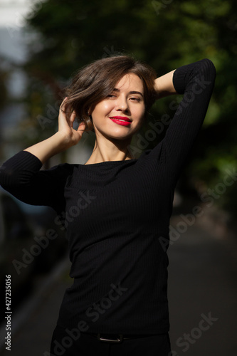 Lovely woman with vivid makeup dressed in classic black clothes