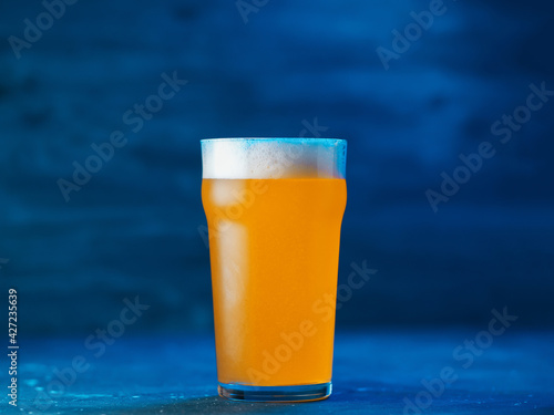 New England IPA craft beer glass on dark blue background photo