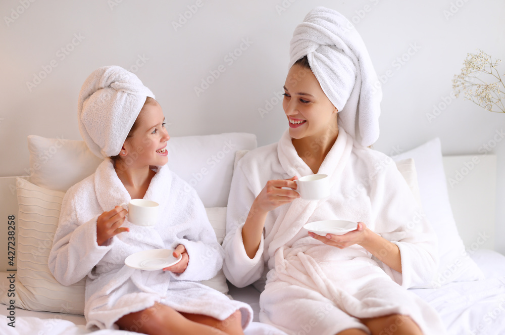 Mother and daughter enjoying hot drink on bed Mother and daughter enjoying hot drink on bed