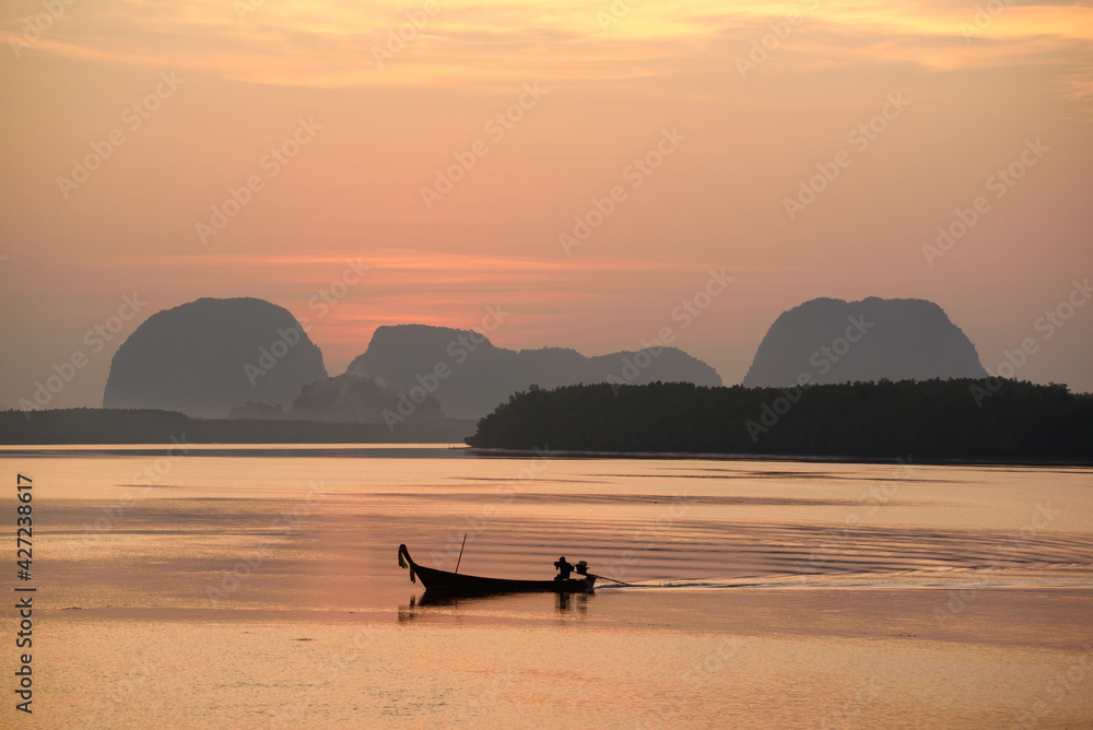 Beautiful view in the morning during sunrise and silhouette of fisherman longtail boats