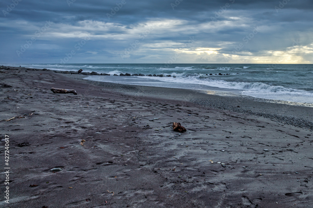 Stormy weather approaching a desolate beach in New Zealand