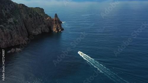 Un bateau de touristes dans la baie du Capu Rossu sur la Méditerranée, en Corse photo