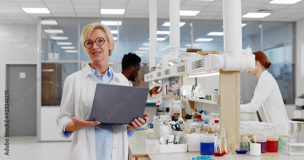 Portrait of female researcher laptop talking on camera about research in chemistry lab