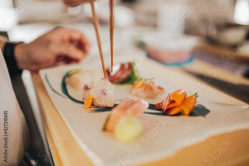 Close up shot of a professional sushi chef preparing sashimi in a restaurant. Traditional Japanese omakase style. Concept of hospitality.