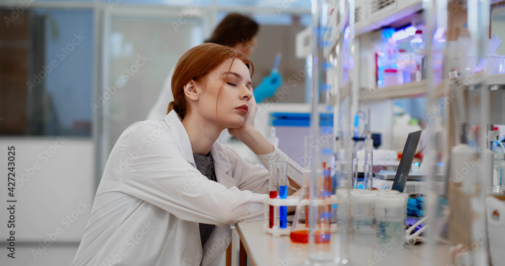 Portrait young woman scientist sleeping feeling tired working in medical laboratory Portrait young woman scientist sleeping feeling tired working in medical laboratory