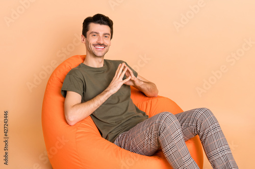 Photo portrait of man sitting in orange chair got idea isolated on pastel beige color background © deagreez