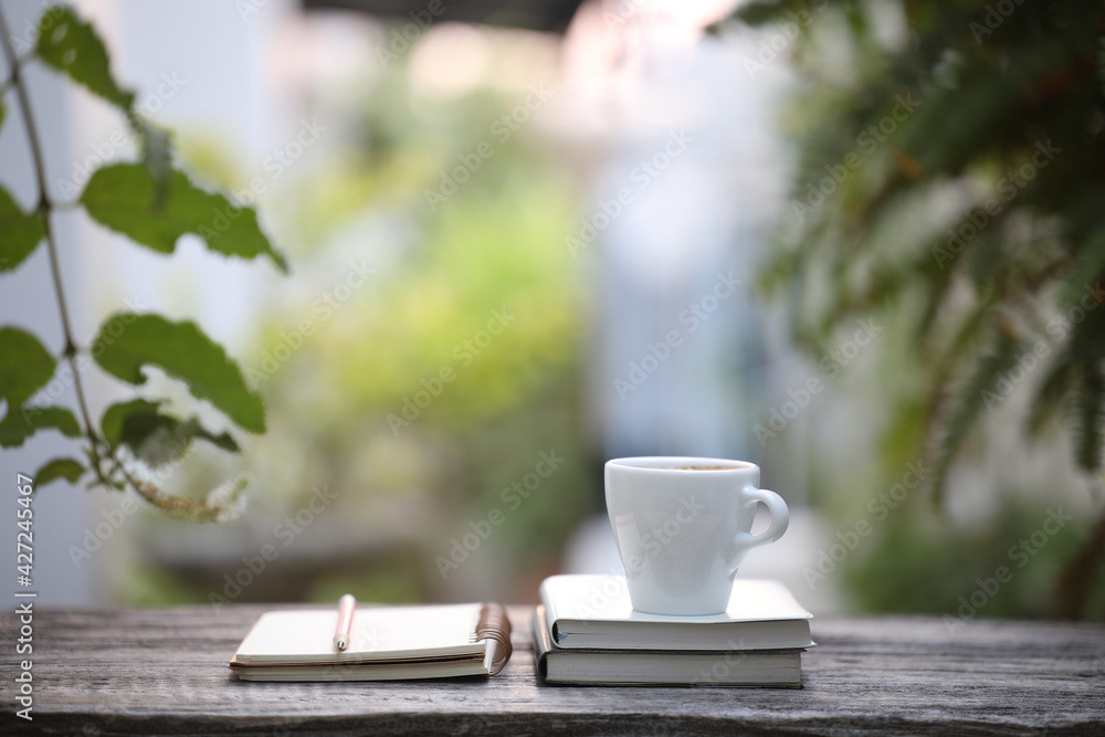 White coffee cup and notebooks with pencil on wooden table at outdoor White coffee cup and notebooks with pencil on wooden table at outdoor