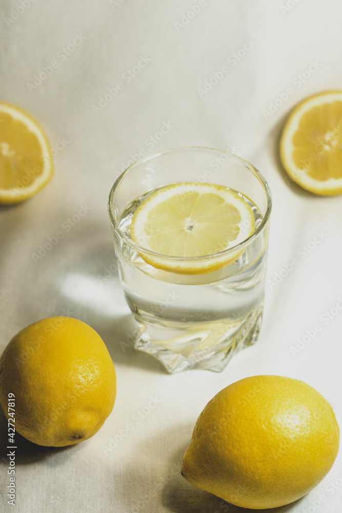 Glass of water with a lemon slice. Lemon cut in half in studio on isolated white background. Glass of water with a lemon slice. Lemon cut in half in studio on isolated white background.