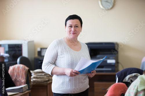  The office is central. Woman office worker with papers