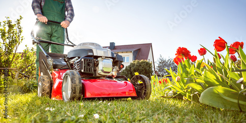 Obraz na plátně Lawn mower in a sunny garden at spring time