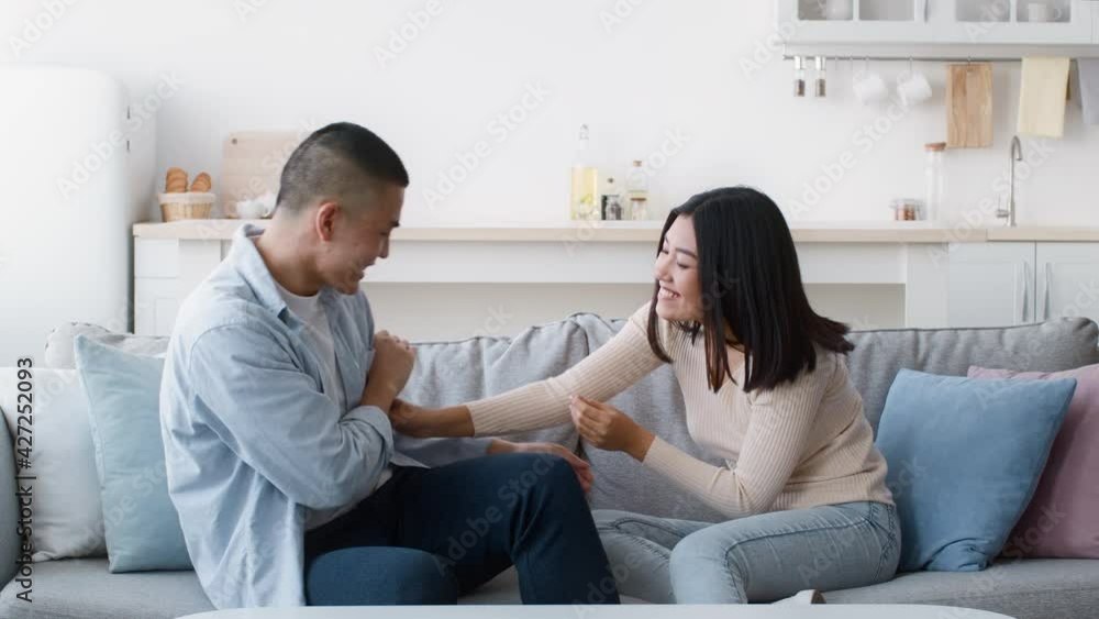 Happy Asian Couple Tickling Each Other Having Fun At Home Happy Asian Couple Tickling Each Other Having Fun At Home