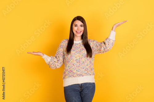 Photo of nice charming young woman hold hands scales empty space present offer isolated on yellow color background